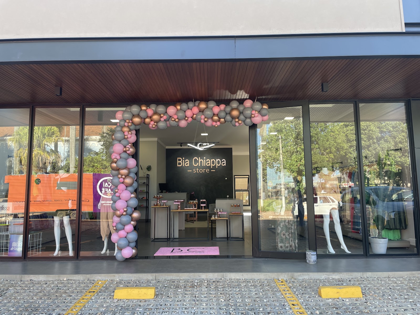 Fachada da nova loja com arco de balões rosa e lilás na inauguração